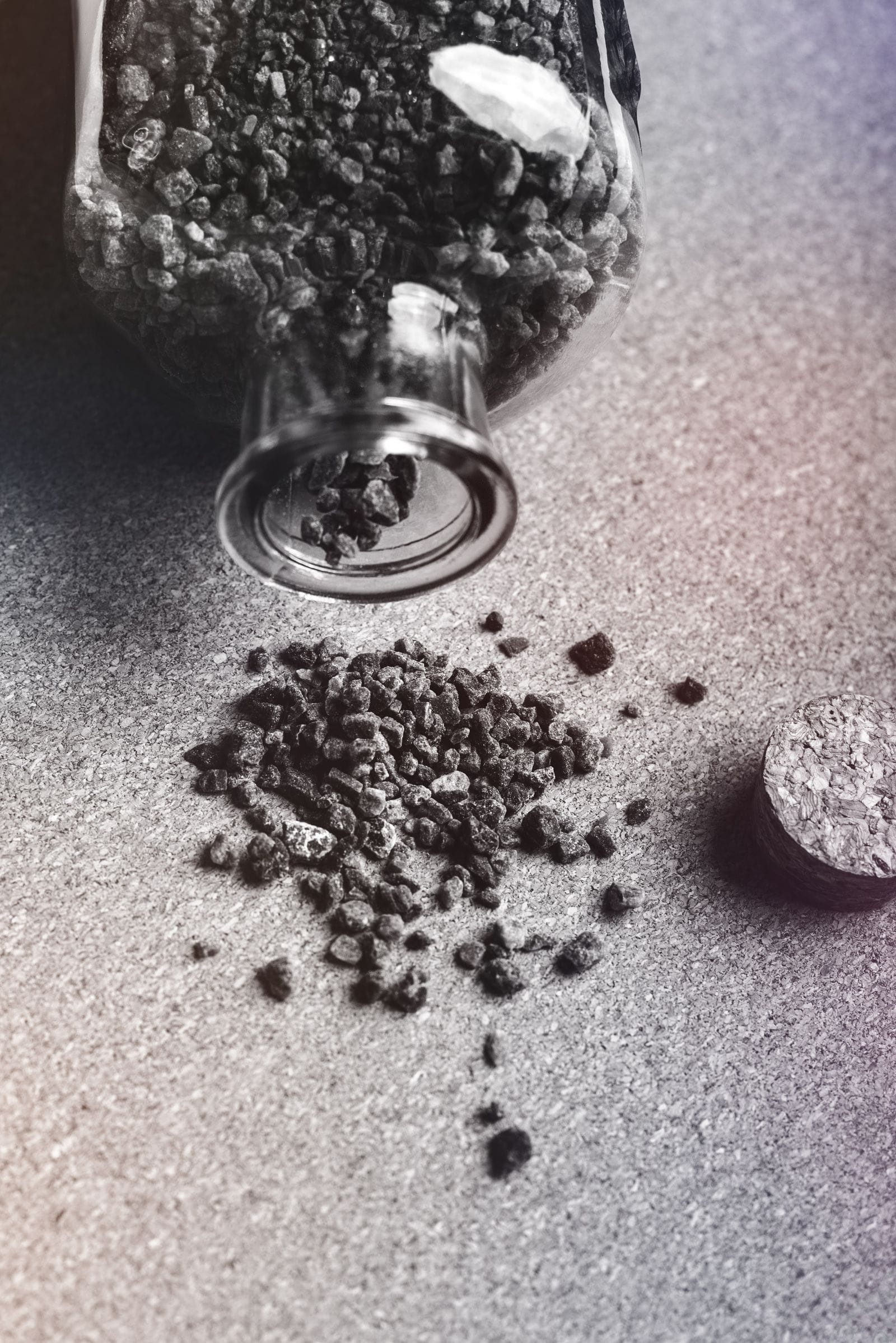 Activated carbon granules poured from a glass jar